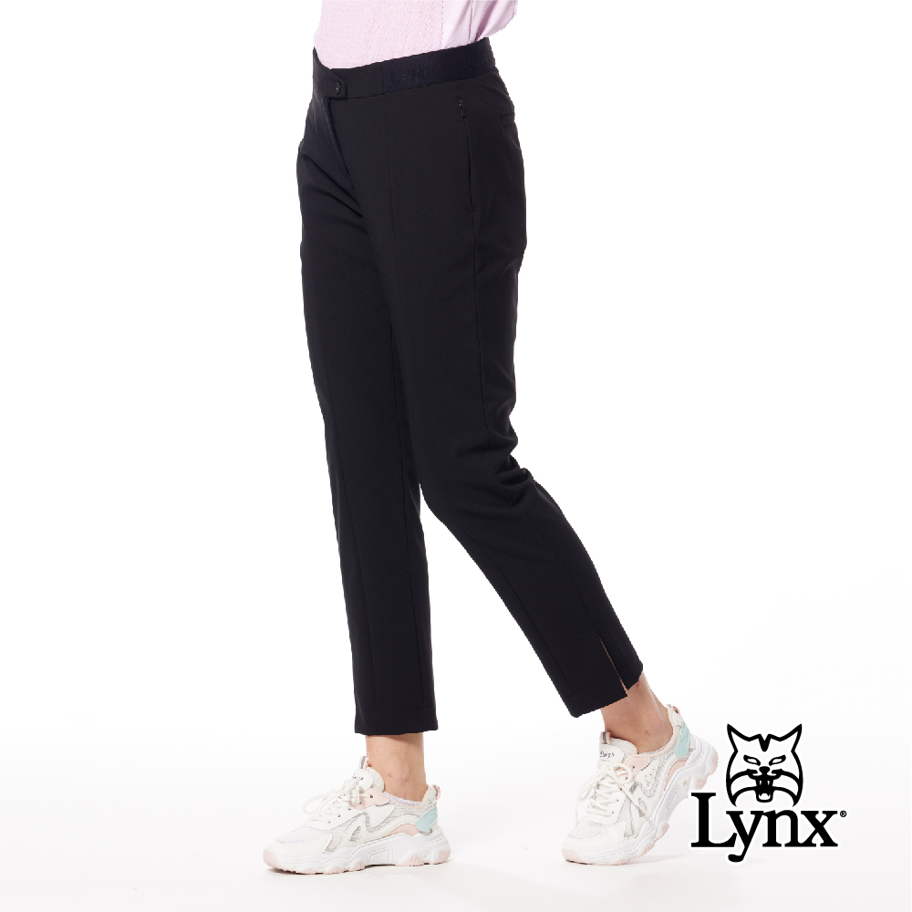 【Lynx Golf】女款日本進口布料彈性舒適隱形拉鍊口袋設計褲口開杈造型窄管九分褲-黑色